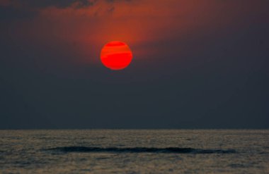 Tam daire kırmızı günbatımı deniz yatay çizgi tarafından harika dramatik alacakaranlık gökyüzü düşüyor 