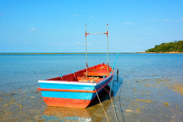 FISHERMAN ROW BOAT AGROUND ON SEA SAND LOW TIDE CORAL BEACH , BEAUTIFUL SUNNY DAY , CLEAR BLUE SKY BACKGROUND