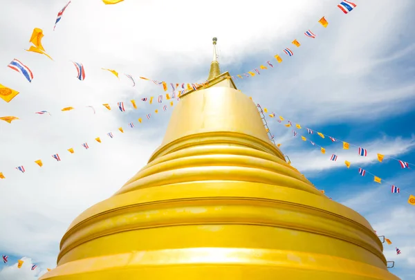 GOLDEN PAGODA AT BUDDHISTS TEMPLE IN THAILAND , SUNNY CLEAR BLUE SKY CLOUD BACKGROUND
