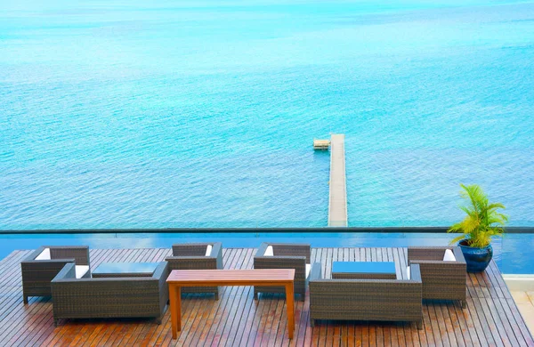 Ev dekorasyonu, havuz, bak Out okyanus manzarası içinde güneşli gün, deniz kıyısında arka plan Lisesinden yanındaki ahşap kol-sandalye 