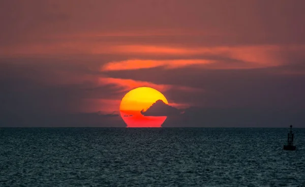 SUNDOWN HIDDEN HORIZON LINE IN OCEAN , OMEGA-SUNSET NATURAL PHENOMENON ,TWILIGHT DRAMATIC SKY BACKGROUND