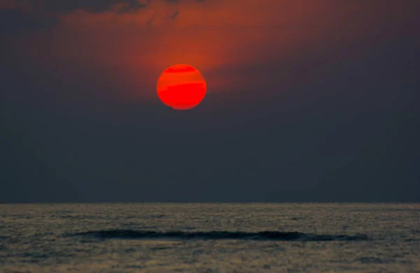 Tam daire kırmızı günbatımı deniz yatay çizgi tarafından harika dramatik alacakaranlık gökyüzü düşüyor 