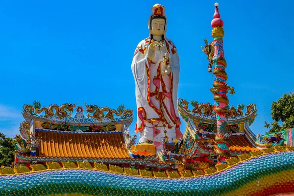 Guan Yin büyük beyaz heykeli pembe lotus kürsüye var bebek vardır sol taraftan binlerce ejderha. Çatıda orada sol ve sağ ejderha.