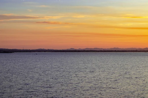 Ağarma Indigo ile turuncu gökyüzü güneş doğuyor ve beyaz bulutlar dağ gölge uzağa giden gördüm