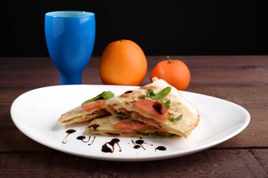 Düz ekmek beyaz tabakta balsamik sirke ile aromalı domates roket ile tepesinde