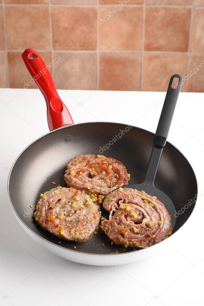 Swivels minced meat with ham, cheese in a pan
