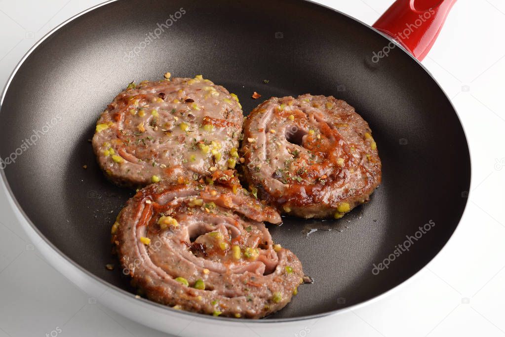 Swivels minced meat with ham, cheese in a pan