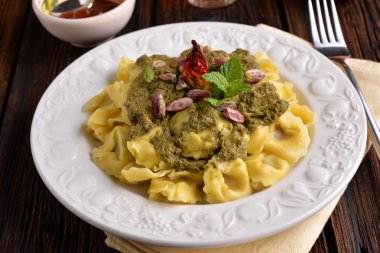 Fıstık krem ve acı biber masada beyaz tabakta Cappelletti makarna