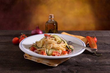 Spagetti yemek kabak pastırma ve ahşap masa üzerinde Adaçayı yağı ile aromalı domates ile