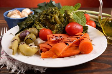 Tabak haşlanmış sebze ve Yeşiller ahşap tahta üzerinde