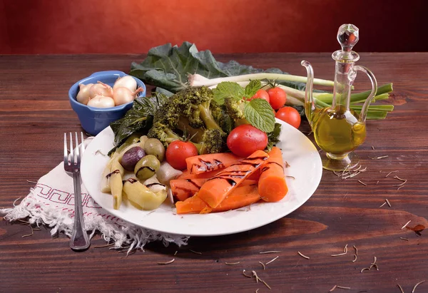 Tabak haşlanmış sebze ve Yeşiller ahşap tahta üzerinde