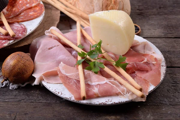 Gesneden hapjes voor antipasti op rustieke tafel — Stockfoto