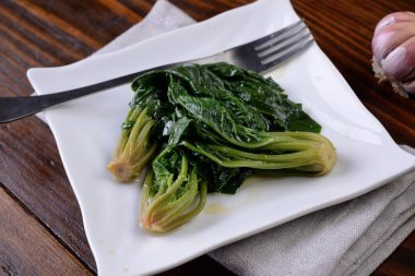 Bir tabak pişmiş ve baharatlı ıspanak.