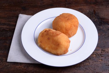 2 Arancine, et, mozzarella ve beyaz tabakta prociutto.