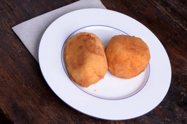 2 Arancine, et, mozzarella ve beyaz tabakta prociutto.