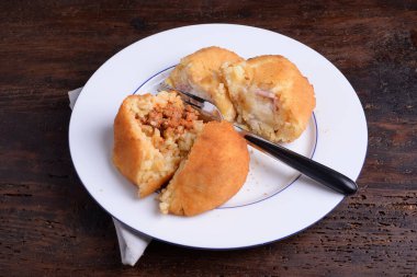 2 Arancine, et, mozzarella ve beyaz tabakta prociutto.