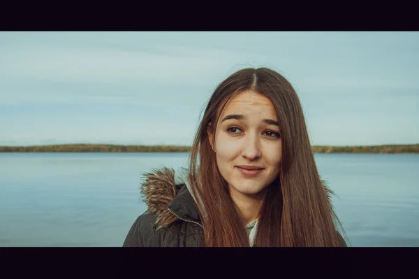 Girl with a funny facial expression against the backdrop of the lake. Amazing emotion. Cinema style.