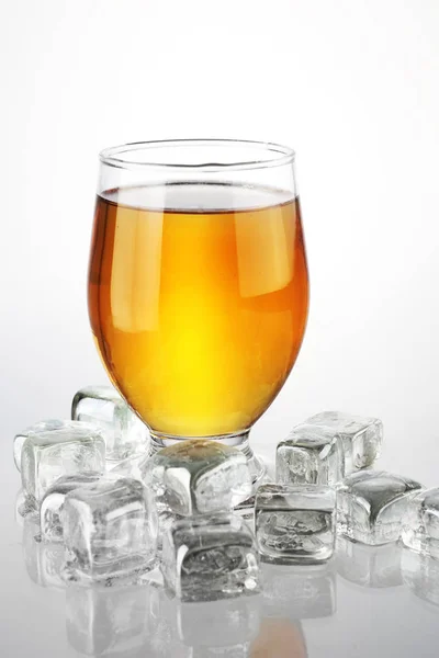 a glass of beer with ice cubes