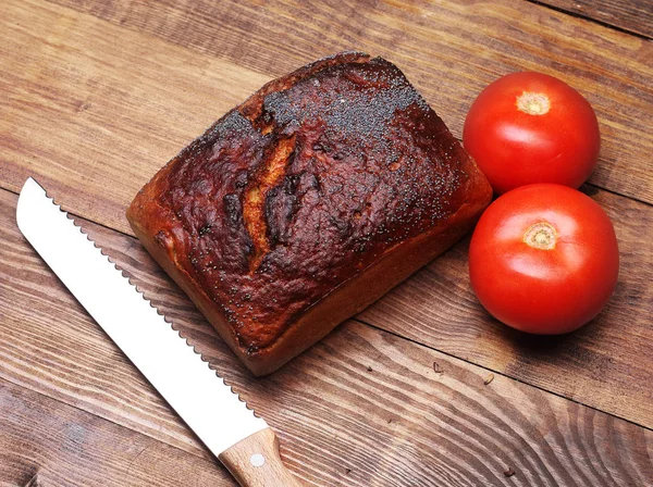 木板上有西红柿和刀的面包 — 图库照片