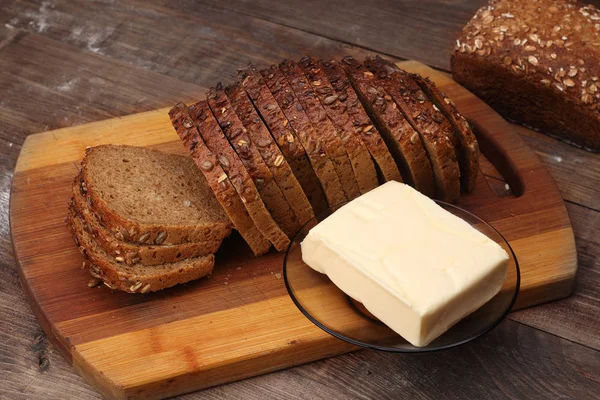 ひまわりとバターでパンを切る — ストック写真