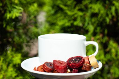 Doğal yeşillik bir arka plan üzerinde kahve ve ev yapımı pastille ile beyaz kupa