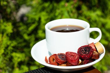 Doğal yeşillik bir arka plan üzerinde kahve ve ev yapımı pastille ile beyaz kupa