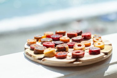 Denizin arka planında taze iştah açıcı pastil ile ahşap çanak