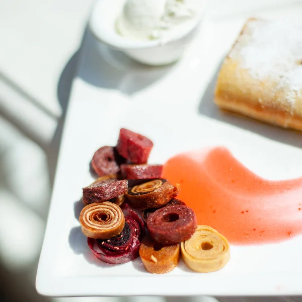 Denizin arka planda bir restoranda beyaz yemek. Çanak tatlı strudel, krema, ev yapımı pastille