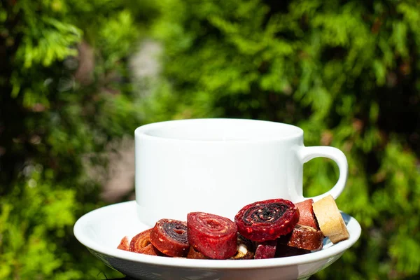 Doğal yeşillik bir arka plan üzerinde kahve ve ev yapımı pastille ile beyaz kupa