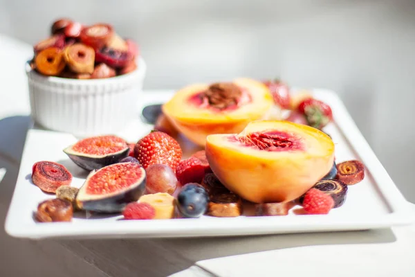 A dish with fruit and pastille on the background of the sea shore. Yummy. Luxuriously.