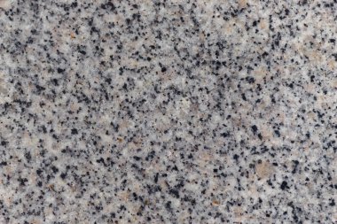 Gri granit, pembe tonları, siyah ve turuncu kirleri ile. Granit yüzey, üst görünüm