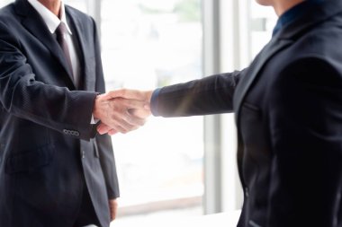 El sıkısıkıya sıkıya sıkıya sıkıya sıkıya sıkıya sıkıya sıkıya layan iki işadamı.