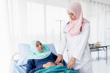 Müslüman doktor hastanın midesini muayene ediyor..