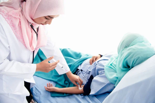 Muslimka žena lékař, který má být injekce rameno pacienta — Stock fotografie