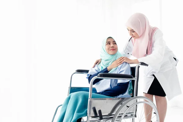 Médico musulmán llevando al paciente en silla de ruedas . — Foto de Stock