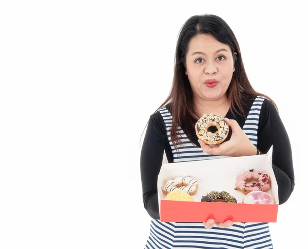 Uma jovem mulher gorda asiática tem um donut na mão . — Fotografia de Stock