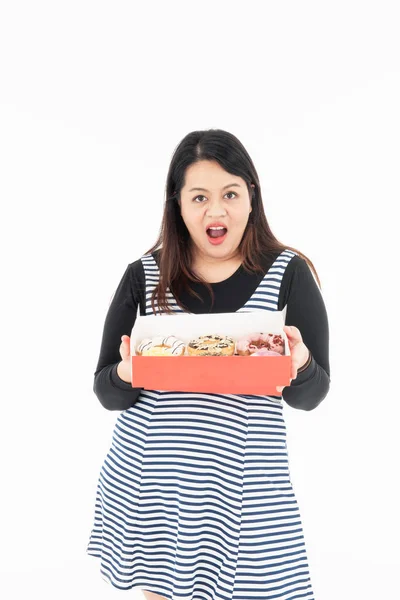 Eine junge asiatische dicke Frau hat einen Donut in ihrer Hand. — Stockfoto