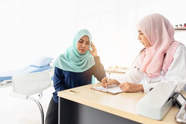 Müslüman doktor hastanın baş ağrısını soruyor.