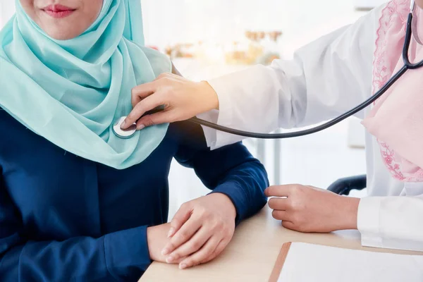 Muslim doctor using stethoscope listen heartbeat.