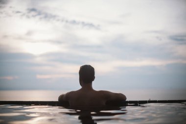 Açık Yüzme havuzunda bir genç yakışıklı bir adam portresi. Havuzun kenarındaki sakallı çekici adam