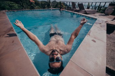 Açık Yüzme havuzunda bir genç yakışıklı bir adam portresi. Havuzun kenarındaki sakallı çekici adam