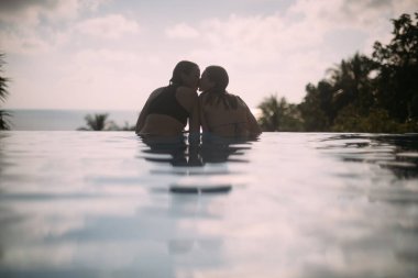 İki genç lezbiyen kızlar gündoğumu, bir açık yüzme havuzunda 