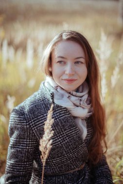 Güneşli bir günde bir kız ormanda portresi. Genç kadın ormanda bir sonbahar akşamı yürür.