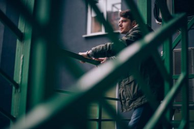 Endüstriyel bir manzara içinde genç bir adam portresi.