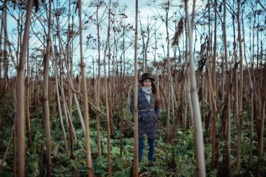 Uzun otların sonbaharın güzel kız. Şapkanı ve paltonu güneşli bir sonbahar alanında genç kadın