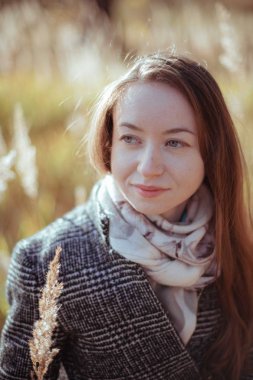 Güneşli bir günde bir kız ormanda portresi. Genç kadın ormanda bir sonbahar akşamı yürür.