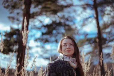 Sonbahar orman arka plan üzerinde genç güzel kadın. Sonbahar güneşli günü kız ormanda portresi