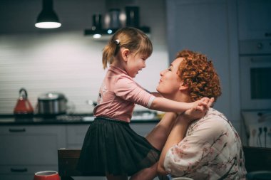 Akşam yemeği için anne ve kızı mutfakta sarılmak. 