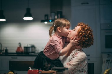 Akşam yemeği için anne ve kızı mutfakta sarılmak. 