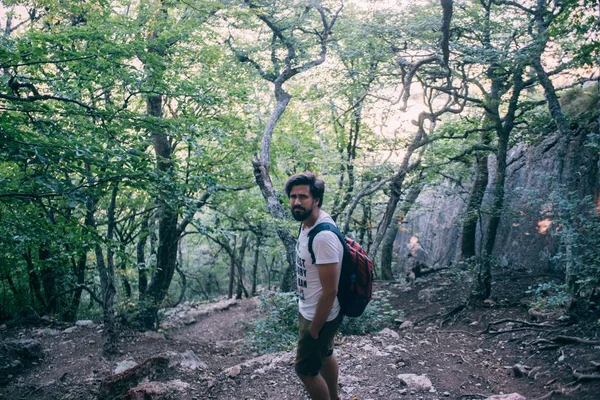 Bir sırt çantası bir yürüyüş gezisi dağlarda olan genç bir adam.